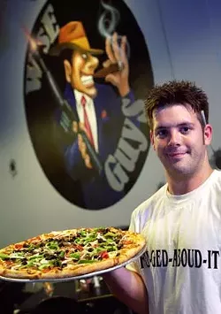 Waiter Will Zebell shows off a Supreme Pizza recently at Wise Guys Bar & Pizzeria. The Supreme pie features a homemade crust topped with tomato sauce, fresh onion, bell pepper, olives, mushrooms, pepperoni, canadian bacon, sausage, and meatball.