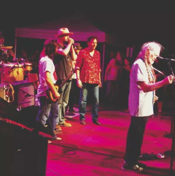 Brad Wheeler playing harmonica for Willie Nelson