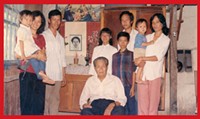 Tam as a child, at left, with his mother & father and the rest of his - family in their home in a village south of Saigon.