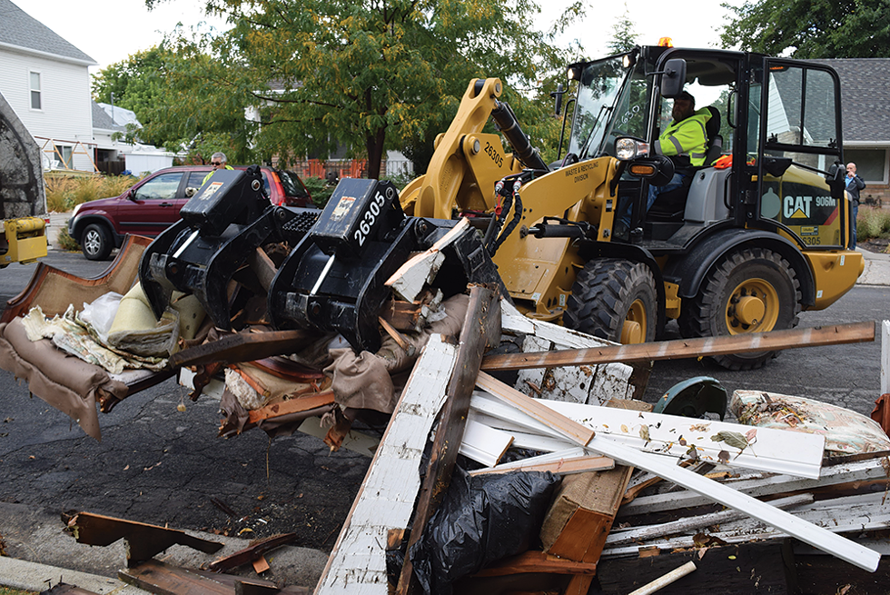 Workers with the city's Call 2 Haul program collect the junk outside Farrina Coulam's East Liberty Park home. - RAY HOWZE