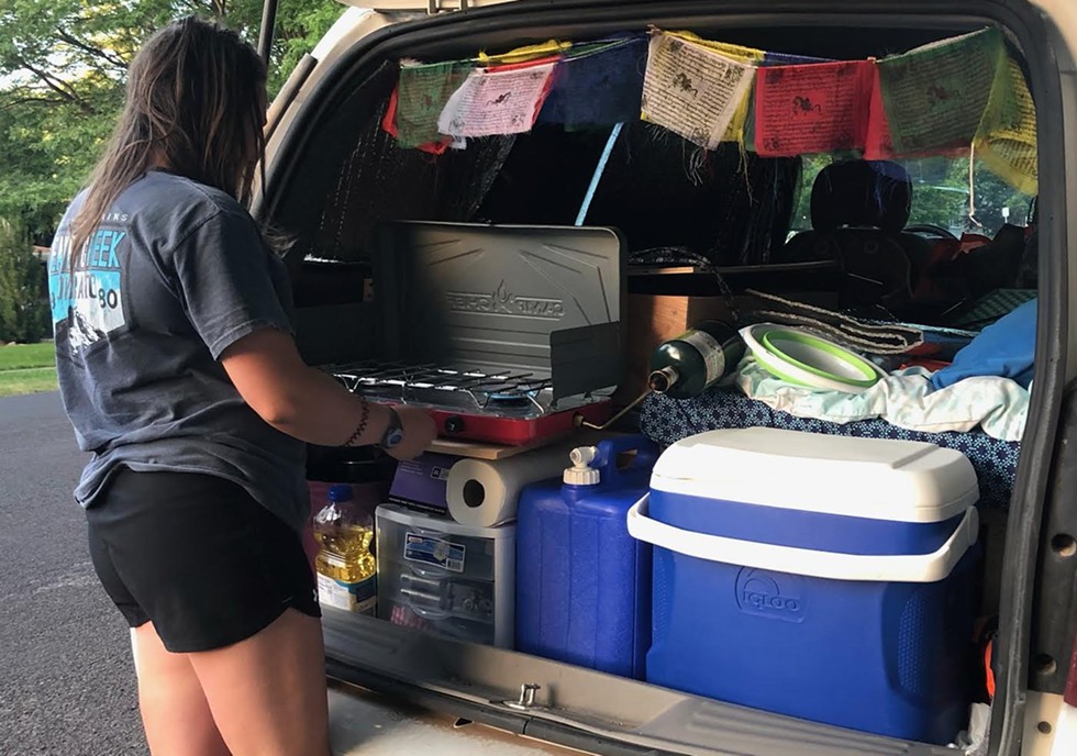 USU student Stephanie Buchanan fires up a quick meal in the cramped-yet-efficient back of Moby Dick, her Chevy Uplander. - COURTESY PHOTO