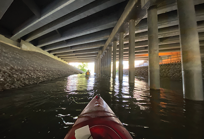 Kayakers pass under Interstate 215 on the Jordan River between Murray and Taylorsville. - BENJAMIN WOOD