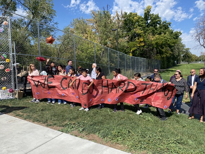 Backman Elementary students carry a "We Can Do Hard Things" banner at the ceremonial opening of a new pedestrian bridge over the Jordan River on Thursday, Sep. 29, 2022. - BENJAMIN WOOD