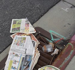 Copies of City Weekly thrown in a downtown gutter - LARRY CARTER