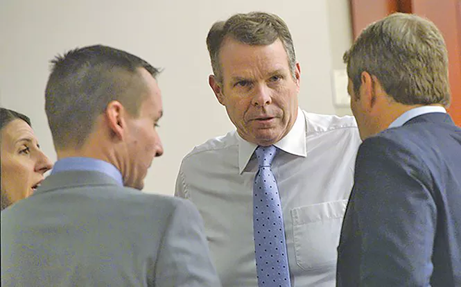 Cara Tangaro (left), Brad Anderson (center) and Scott Williams (right) surround their client, John Swallow, on Wednesday, Feb. 15. - AL HARTMANN/COURT POOL