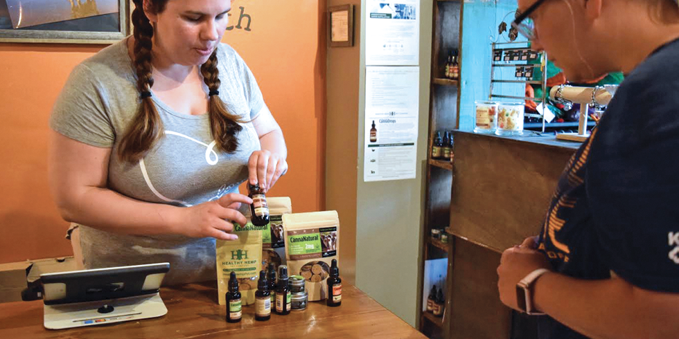 Aspen Anderson, left, explains the the properties of CBD products to pet owner Lindsey Hazelwood. - RAY HOWZE