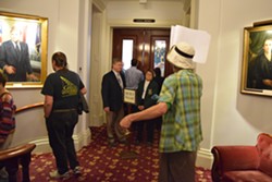 Protesters pass by the Senate chamber as Senate President Pro Tempore John Campbell and Sergeant-at-arms Janet Miller look on. - TERRI HALLENBECK