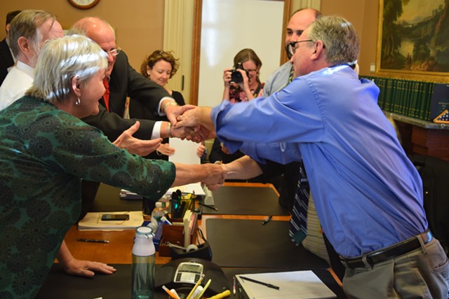 House and Senate education conferees shake hands after reaching an agreement on a school district consolidation bill Thursday evening. - TERRI HALLENBECK