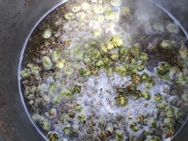 Local homebrewer Bryce Healy adds hops to his brew in South Burlington. - IMAGE COURTESY OF BRYCE HEALY