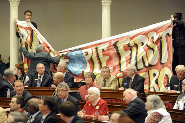 Sergeant-at-Arms Francis Brooks pulls down a banner held by single-payer protesters at Gov. Peter Shumlin's inauguration. - JEB WALLACE-BRODEUR