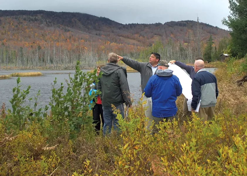 State officials and Adirondack Club and Resort representatives discussing the proposal alongside Cranberry Pond in 2011 - COURTESY OF JESSICA COLLIER OF THEADIRONDACK DAILY ENTERPRISE