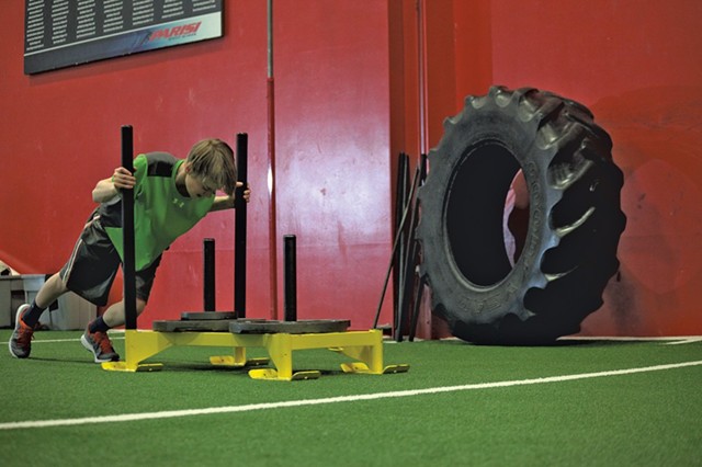 Matt Reinfurt, 13, pushes the Prowler Sled, a tool used in Parisi to develop speed and strength. - MATTHEW THORSEN