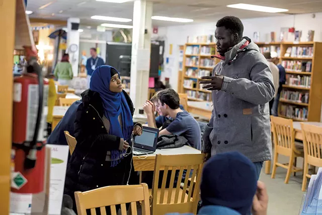 Yuol Herjok of Spectrum Youth & Family Services (right) speaking with Burlington High School senior Halima Said at the school's Spectrum Multicultural Help Desk - GLENN RUSSELL