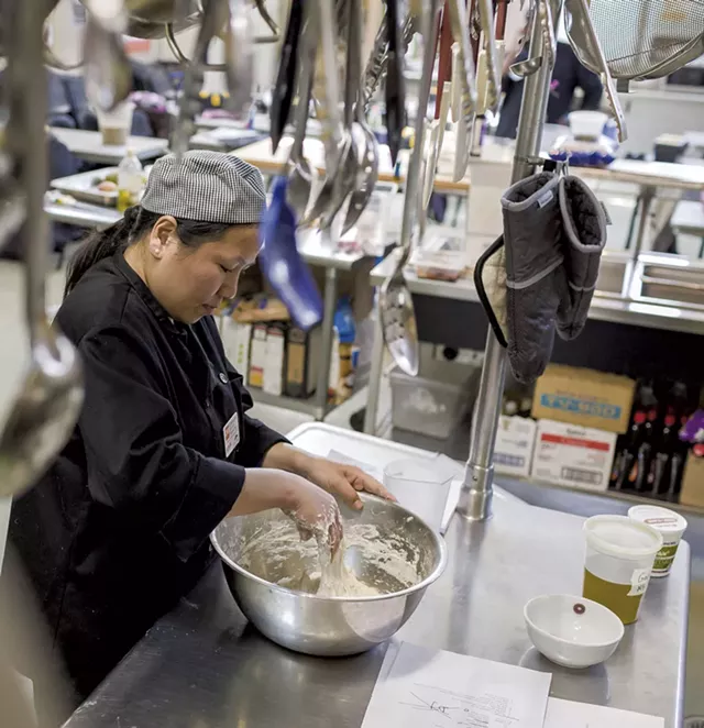 Maya Gurung-Subba mixing batter at the - Chittenden Emergency Food Shelf in Burlington - OLIVER PARINI