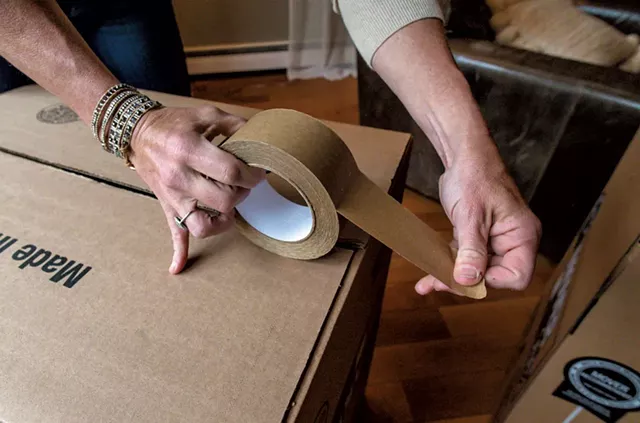 Marlene Simson packing a moving box - GLENN RUSSELL