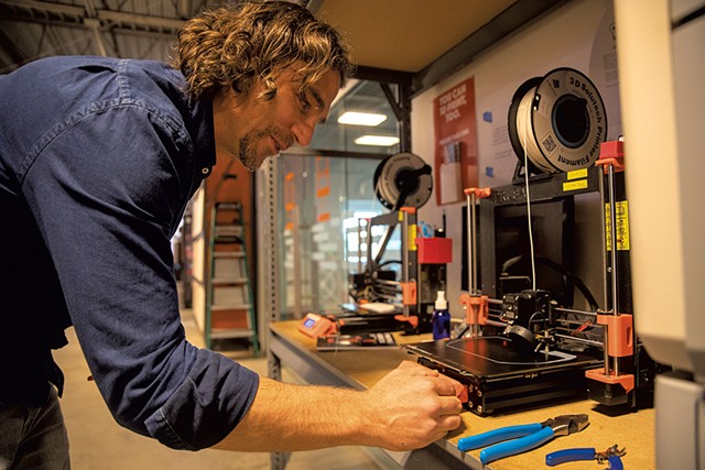 Travis Vogel working with a 3D printer - JAMES BUCK