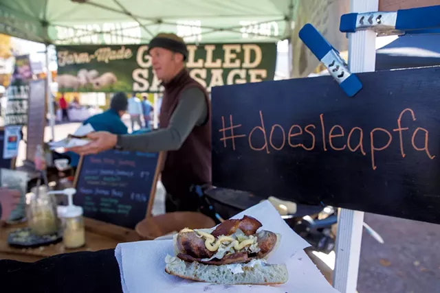 George van Vlaanderen serving a grilled sausage sandwich at the Doe's Leap Farm booth - JAMES BUCK