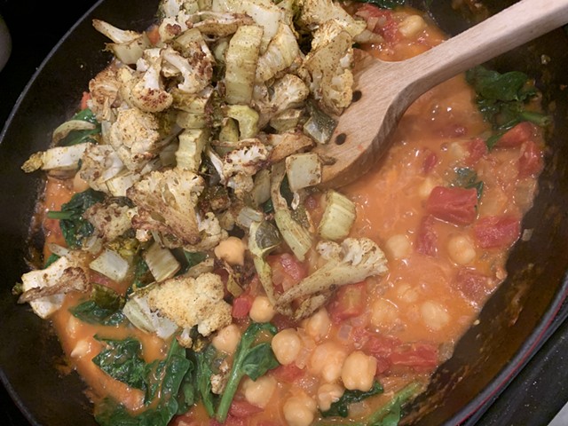 Stirring roasted cauliflower into the curry - MELISSA PASANEN