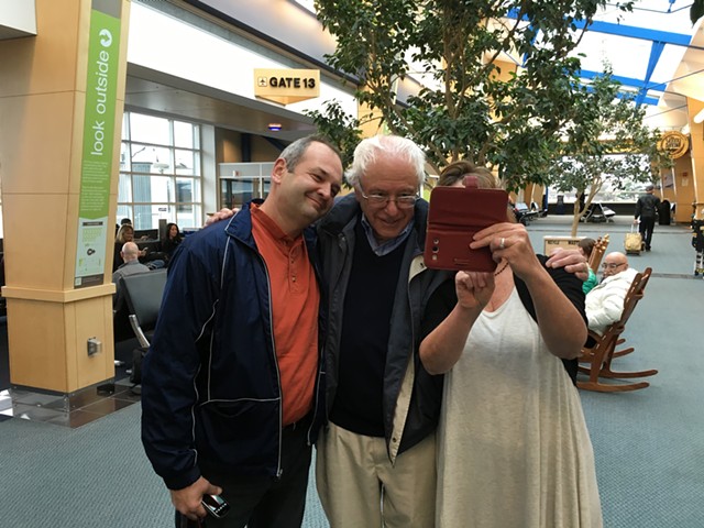 Sen. Bernie Sanders poses for selfies at Burlington International Airport Friday on his way to a debate in Des Moines. - PAUL HEINTZ