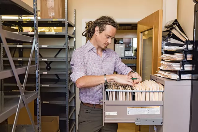 Chief herbalist Guido Masé combing through paperwork - OLIVER PARINI