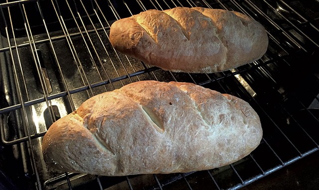 Loaves of hearth bread coming out of the oven - MARY ANN LICKTEIG