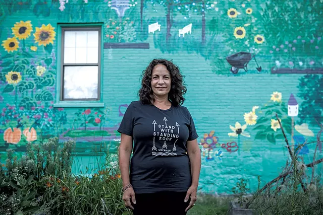 Gina Carrera standing in front of her mural on South Champlain Street - FILE: LUKE AWTRY ©️ SEVEN DAYS