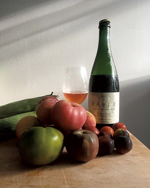 A bottle of Vinous Venus from Fable Farm Fermentory and late summer produce - JORDAN BARRY ©️ SEVEN DAYS