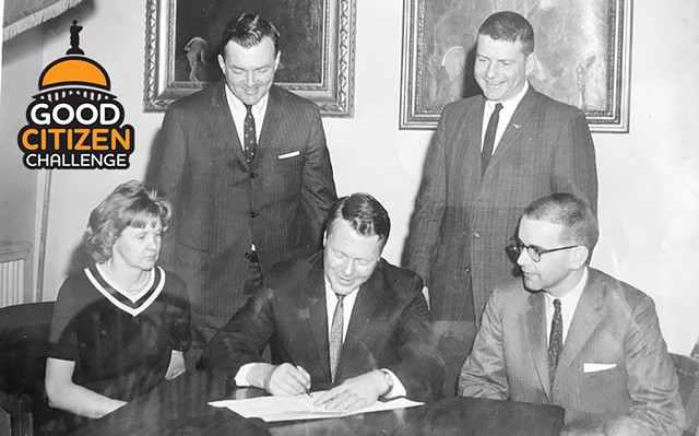 Governor Phil Hoff signing the billboard bill into law. Ted Riehle is standing on the right. Then-representative Tom Salmon, House minority leader, is standing on the left. - COURTESY OF RIEHLE FAMILY