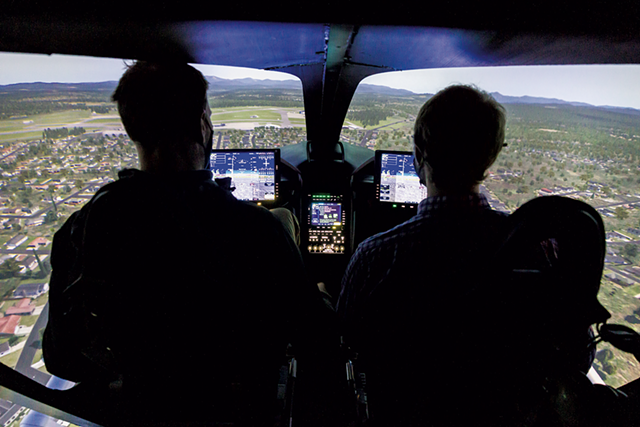 Beta Technologies CEO Kyle Clark operating the company's flight simulator with reporter Derek Brouwer - OLIVER PARINI