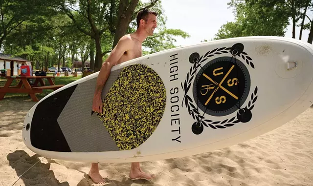 A paddleboarder on the beach - BEAR CIERI