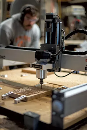 Nathaniel Klein running a CNC machine - CALEB KENNA