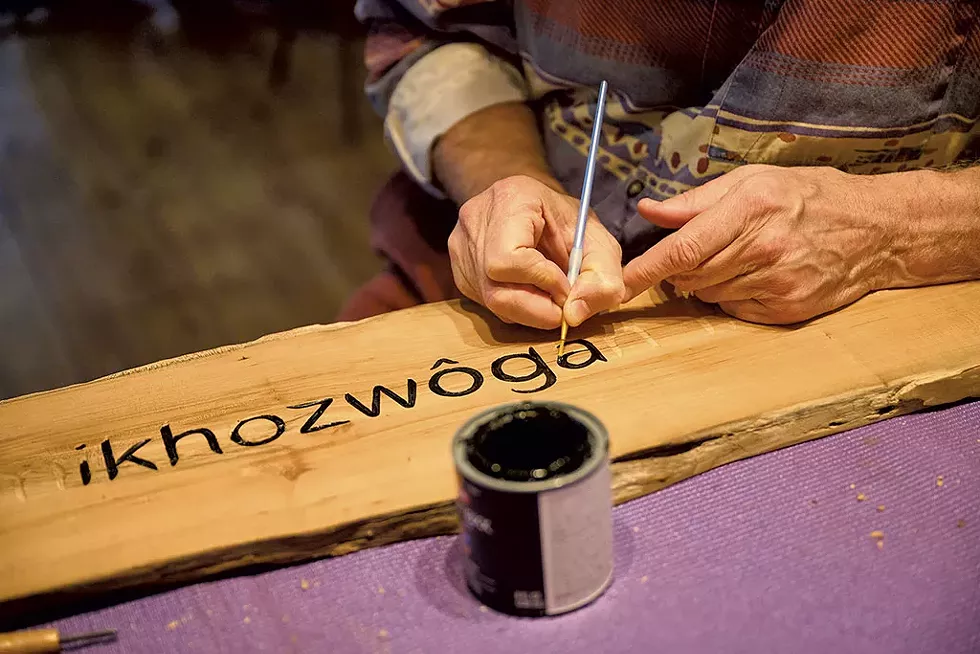 Tim Brookes working on an Abenaki piece that reads "Please honor the pledge," which is directed to students in the Abenaki course at Middlebury College to speak Abenaki rather than English outside of class time - BEAR CIERI
