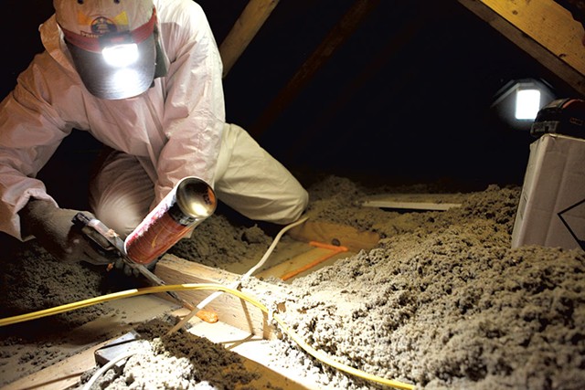 Brian Hyde of Energy Co-op of Vermont sealing gaps in a Colchester attic - FILE: KEVIN MCCALLUM