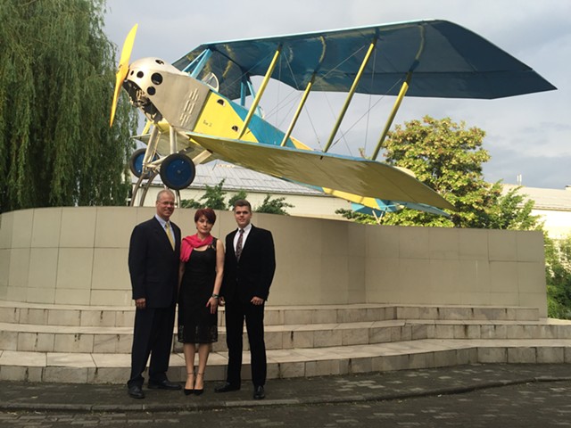 Jim and Larissa Haas and their youngest son in front of an old Soviet plane at his aviation school graduation - COURTESY