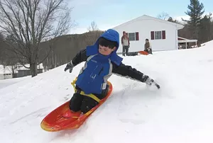 Sledding in a Warren backyard