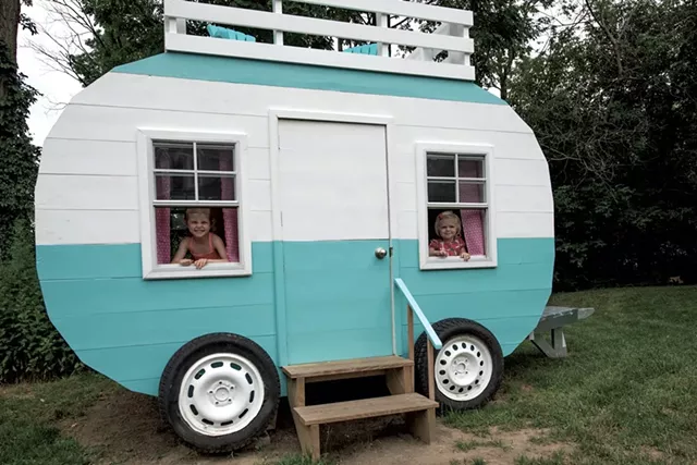 Nora and Claire peek through the working windows of their new playhouse - COURTESY OF RICH LEVINE