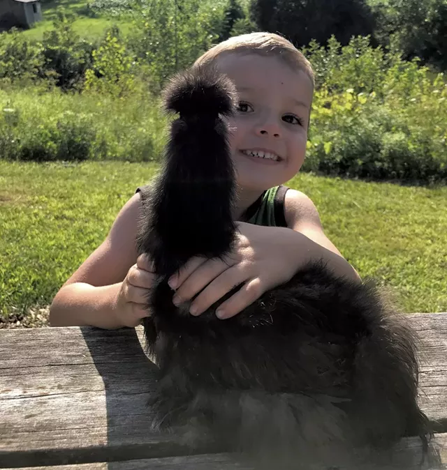 Orion Ronark with a chicken - BRETT ANN STANCIU