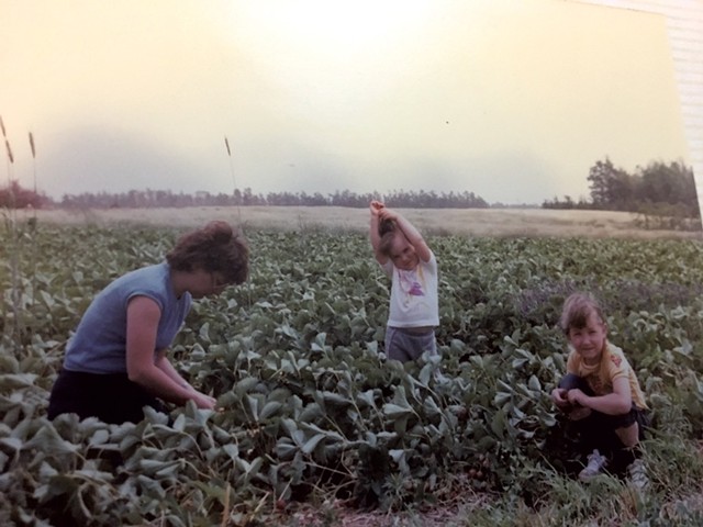 Amy (center) with her mom and sister in 1984, harvesting strawberries in Nova Scotia