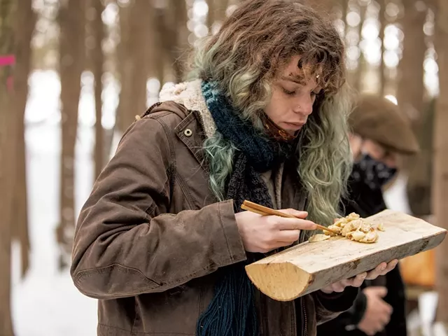 Student Ava Collins using a log as a lunch plate - CAT CUTILLO
