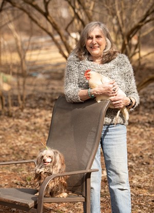 Tomasi holding a chicken alongside her dog Gigi - CAT CUTILLO