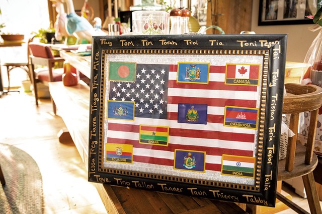 A plaque with flags showing the birth countries of Tomasi's children - CAT CUTILLO