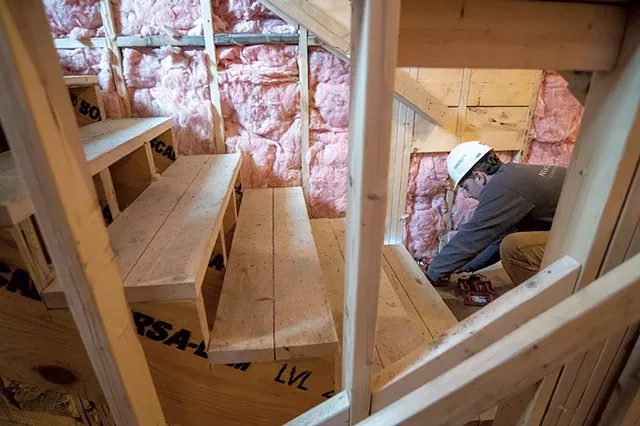 Cameron Palmer working on stairs at the Village Center Apartments - JEB WALLACE-BRODEUR