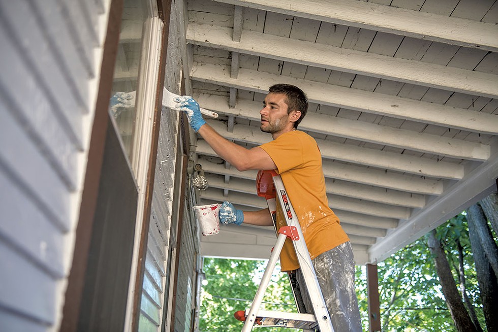 Michael Luisi painting the porch at 25 Intervale Avenue in Burlington - DARIA BISHOP