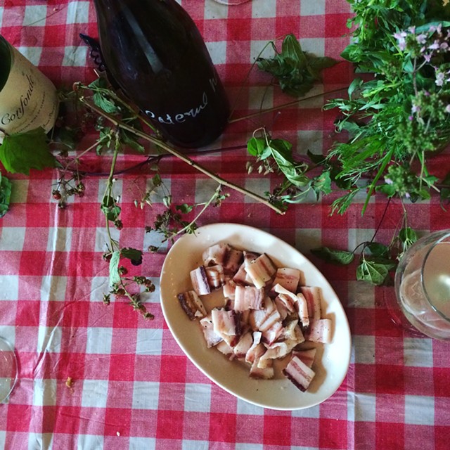 A bottle of Ci Confonde and Caleb Barber's homemade pancetta - JULIA CLANCY