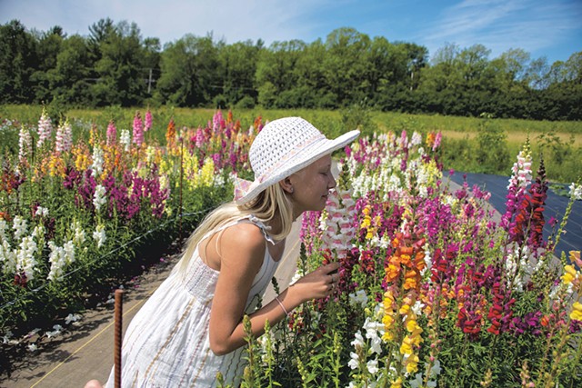 Astri Feiker smelling the flowers at her family's Glory Flower Farm in Charlotte - CALEB KENNA