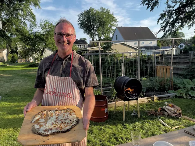 Richard Gliech holding a tarte flambée in front of a WoodFyred oven - MELISSA PASANEN