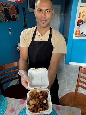 Chef-owner Dhanbahadur Chhetri with chicken chili takeout - MELISSA PASANEN