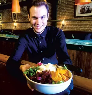 Server Aiden Lavigne with Bobcat Café & Brewery's Big Salad, made with ingredients from ACORN's online marketplace - COURTESY