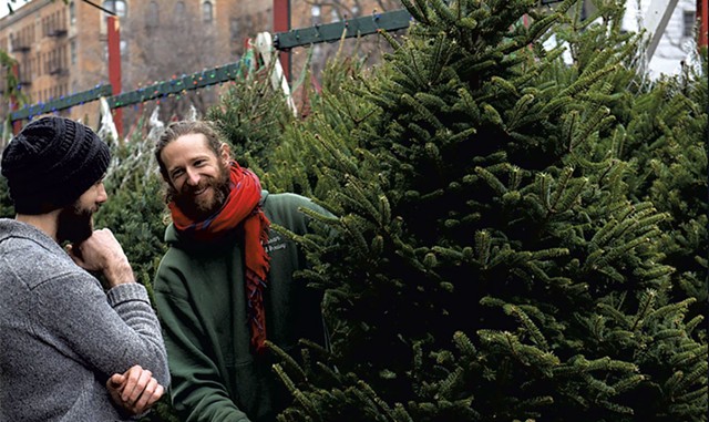 A Christmas tree seller helping a customer - COURTESY OF UPTOWN CHRISTMAS TREES