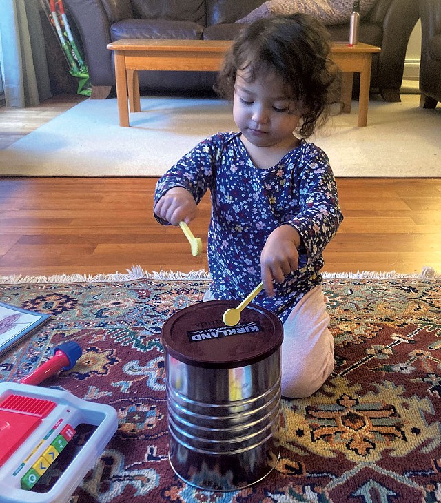 Malia using an old coffee tin as a drum - MARIA MUNROE